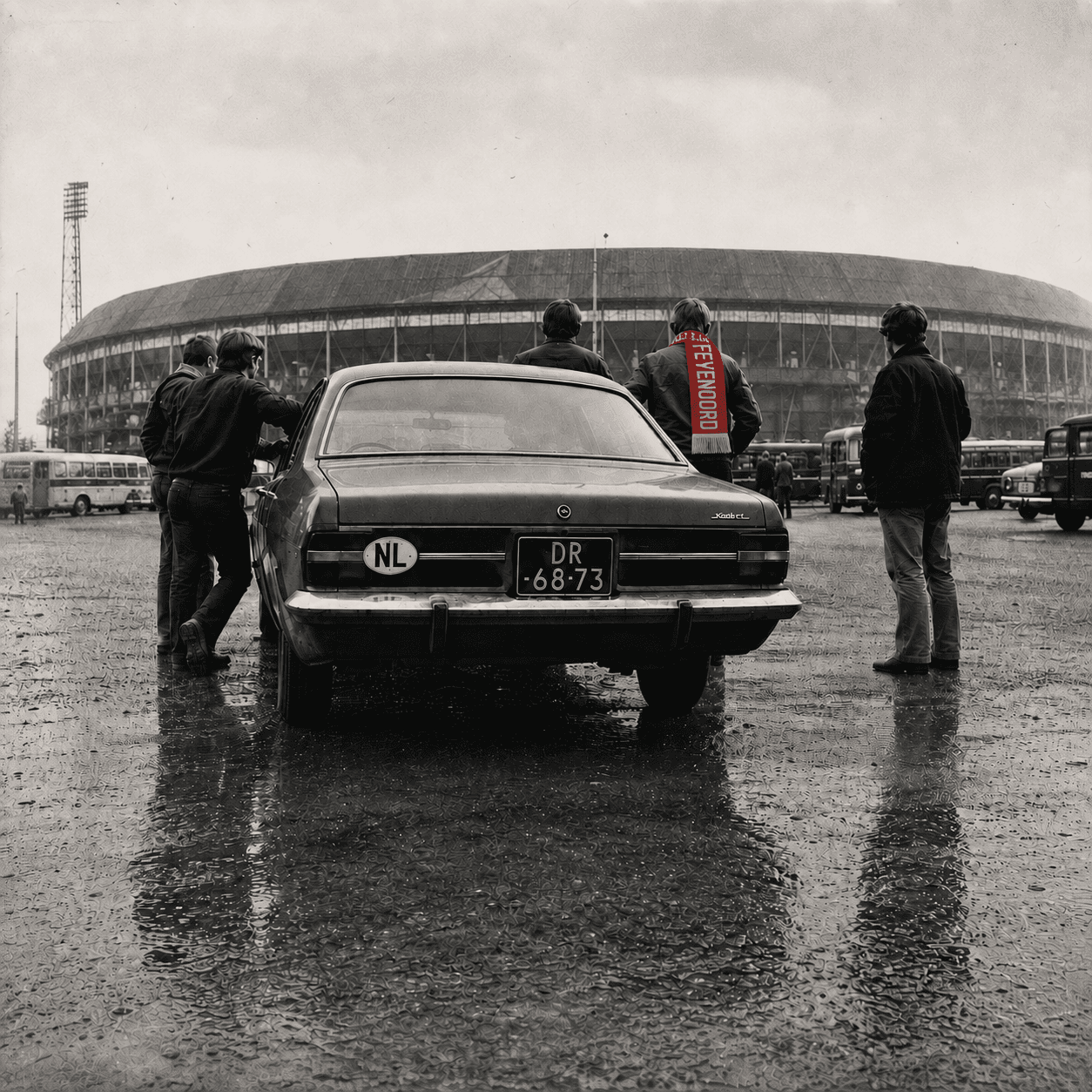 Feyenoordsupporters rond een Opel voor De Kuip op een regenachtige dag.